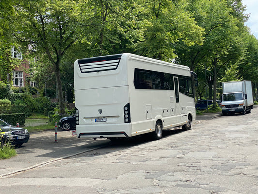 Ein Concorde Wohnmobil unter grünen Bäumen auf einer Straße.