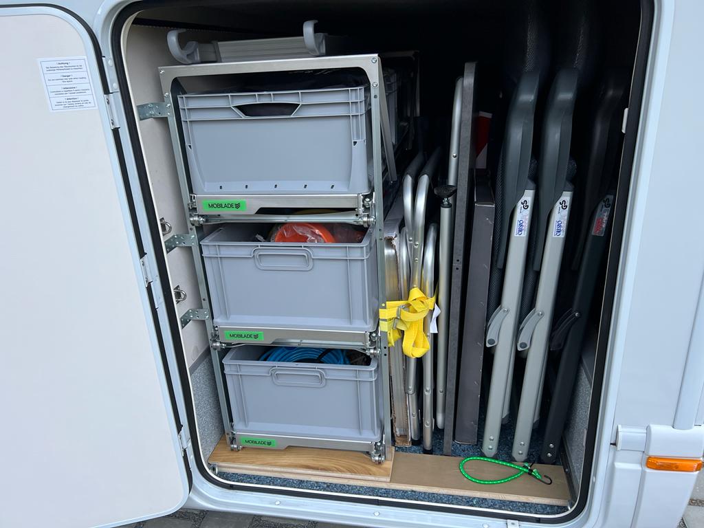 Die Aufbewahrung in einem Aluminium Regalsystem in einer Heckgarage nutzt den Stauraum optimal aus.